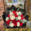 Bouquet of red and white roses with eucalyptus in black wrap