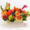 Bright mixed flower arrangement in a white wooden box