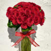 Bouquet of red roses in a clear glass vase with a red ribbon