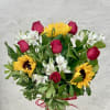 Bouquet of red roses, sunflowers, and white alstroemeria in a glass vase