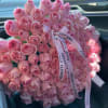 Large bouquet of pink roses tied with a printed ribbon