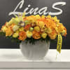 Orange and yellow floral arrangement in a white vase