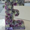 Large floral letter "F" covered in pastel roses