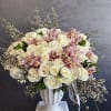 Large bouquet of white roses and pink orchids in a white vase