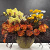 Orange roses and yellow orchids in a woven basket