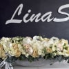 Long low arrangement of cream and blush roses in a silver bowl