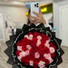 Large bouquet of red and pink roses wrapped in black paper
