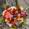 Large bouquet of pink, orange, yellow, and white flowers with eucalyptus