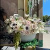 Large white and blush floral arrangement in a textured bowl vase