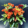 Orange roses and dark red chrysanthemums in a clear glass vase