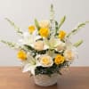 White lilies and yellow roses arranged in a woven basket