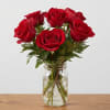 Red roses arranged in a clear glass jar vase