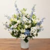 White and blue mixed flower arrangement in a white vase