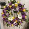 Circular floral wreath with purple, yellow, and white blooms