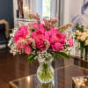 Pink peony bouquet in a clear glass vase with white filler flowers