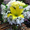 Yellow lily bouquet with white daisies in a glass vase