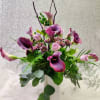 Purple calla lilies and pink roses in a white vase