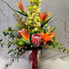 Tall tropical arrangement with orchids, bird of paradise, and lilies in a vase