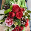 Bouquet of red roses, pink carnations, and white lilies with pinecones