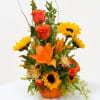 Orange and yellow floral arrangement in a pumpkin-shaped container