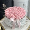 Pink roses arranged in a round silver box with a pink ribbon