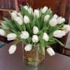 An elegant vase, wrapped with whimsical curly willow, holds 40 decadent white