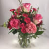 Pink roses and carnations in a clear glass vase