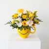 Yellow and white flower arrangement in a smiley-face mug