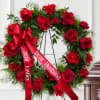 Red rose wreath with a red ribbon on a stand