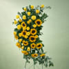 Tall arrangement of yellow roses and sunflowers on a stand
