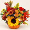 Autumn bouquet with sunflowers, chrysanthemums, and roses in a pumpkin vase