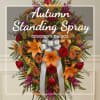 Autumn standing spray with orange lilies, red roses, and a silver bow