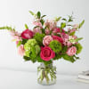 Pink roses and lilies arranged in a clear glass vase