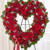A striking all-red standing spray arranged in an open heart design, symbolizing