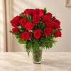 Red roses arranged in a clear glass vase