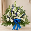 White and blue floral arrangement with a blue ribbon in a white vase