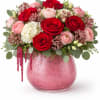 Pink and red rose bouquet in a pink glass vase