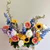 Mixed bouquet in a wooden box with sunflowers, gerbera daisies, and blue flowers
