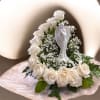 White roses and delicate fillers with a white ceramic angel centerpiece in