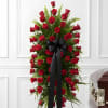 Tall standing spray of red roses with a black ribbon bow
