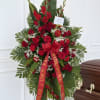 Standing red rose funeral spray with ribbon on a casket