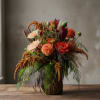 Autumn bouquet with orange and peach flowers in a glass vase