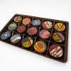 Tray of assorted decorated chocolates in a plastic box