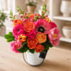Bright mixed bouquet in a white textured vase on a table