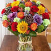 Mixed bouquet of roses, gerbera daisies, and carnations in a glass vase