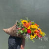 Large mixed bouquet in a woven basket with sunflowers and orange blooms