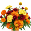 Basket arrangement of orange, yellow, and burgundy flowers