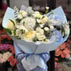 Large bouquet of white and pale blue flowers wrapped in light blue paper