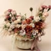 Large bouquet of blush roses, carnations, and orchids in a pale pumpkin vase