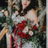 Bride holding a cascading bouquet of red and white roses